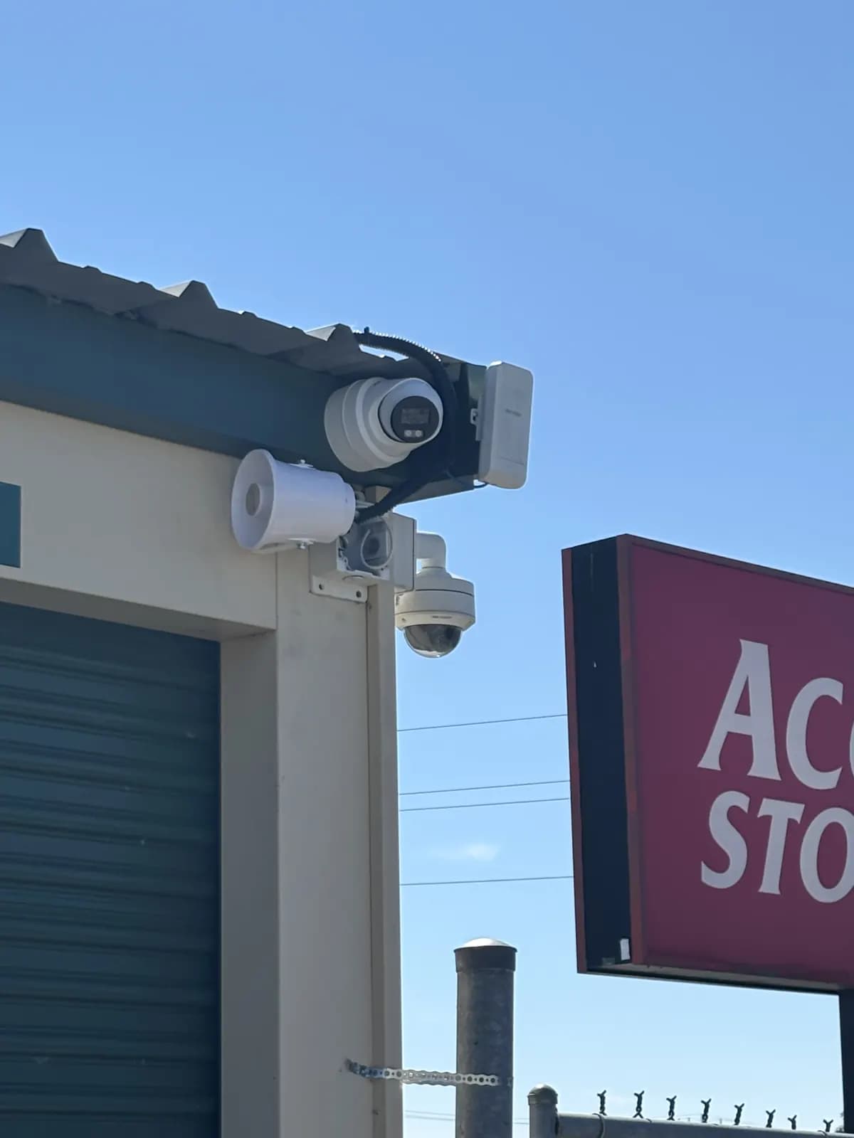 Turret cameras and a PTZ camera mounted on a storage facility building next to the Access Storage sign